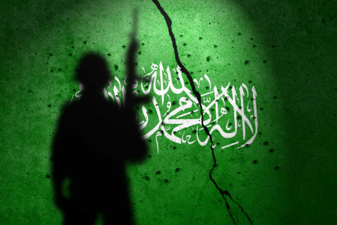soldier-shadow-flag-of-hamas2372966609jpg Silhouette of armed soldier before cracked green wall with white script