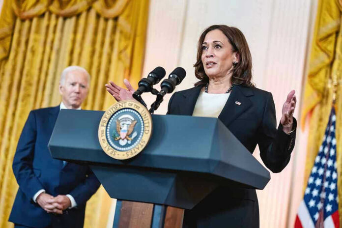 2440267731 Two people speaking at a podium with microphones.