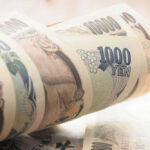 Stack of rolled Japanese yen banknotes.