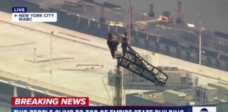 Two people climb to the top of Empire State Building spire, unfurl banner