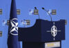 Spending Explosion: NATO Eyes 5% by 2035 NATO podium with flags and microphones.