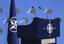 Spending Explosion: NATO Eyes 5% by 2035 NATO podium with flags and microphones.