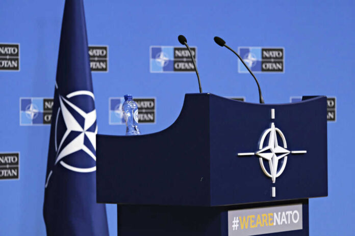 nato283194314 NATO podium with flags and microphones.