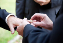 Priest at Gay Wedding Sparks Firestorm Person wearing rainbow ribbon and heart pin on denim