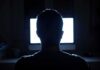 Creepy Backrooms Go Mainstream — Guess Who’s Cashing In person silhouetted in front of a bright computer screen