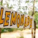 Lemonade stand sign with bold yellow letters outdoors