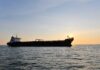 Cargo ship sailing on the ocean during sunset