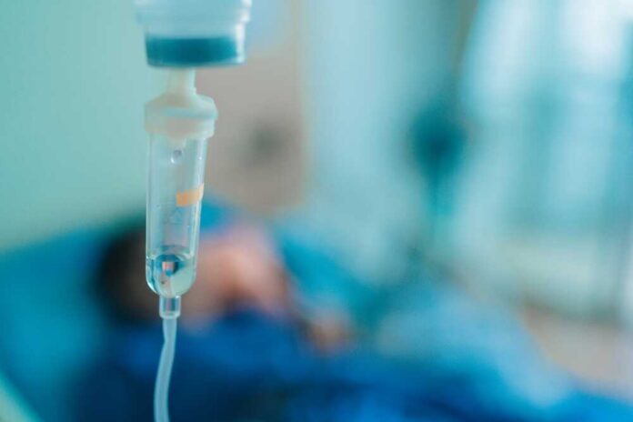 Close,Up,Saline,Iv,Drip,For,Patient,And,Infusion,Pump Close-up of an IV drip in a hospital setting with a patient in the background