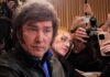 Deportation Over ‘Hate’? Milei’s Wild Move Man surrounded by reporters with cameras and phones