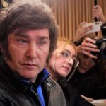 Man surrounded by reporters with cameras and phones