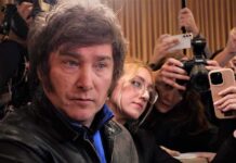 Deportation Over ‘Hate’? Milei’s Wild Move Man surrounded by reporters with cameras and phones