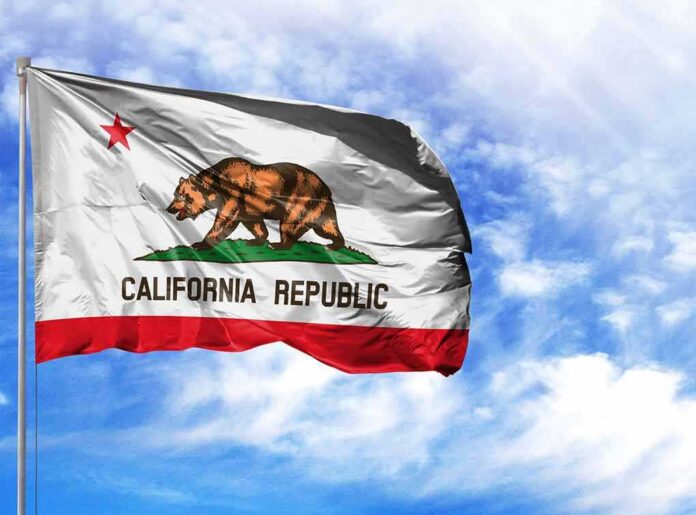 shutterstock_1209468139 California state flag waving against a blue sky
