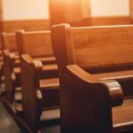 Wooden church pews in warm sunlight