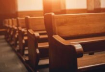 Wooden church pews in warm sunlight