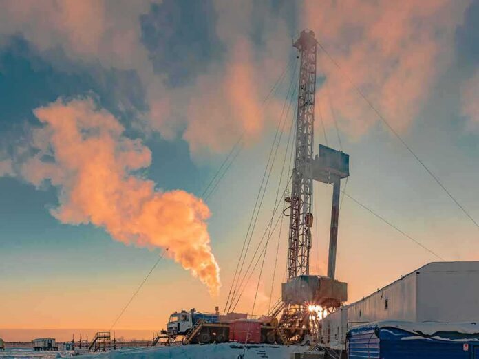 shutterstock_1286735821 Oil drilling rig at sunset releasing steam