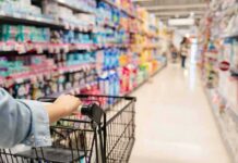 Grocery Giant FoldsâSummer Prices Slashed Shopper pushing a cart down a supermarket aisle