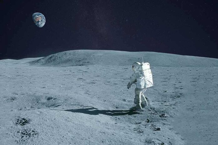 shutterstock_1565414791 Astronaut walking on the Moon with Earth in the sky