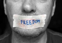Court Smacks Gag Tactic — Free Press Wins A mans mouth is covered with a piece of tape that has the word FREEDOM written on it
