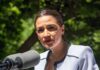 Women’s Sports Line Drawn — AOC Protests woman speaking at an outdoor microphone