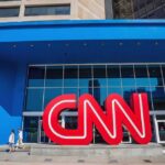 Exterior view of the CNN building with a large red logo and blue facade