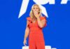 From Congress To Cameo — Why Now? Woman in red jumpsuit on stage blowing a kiss