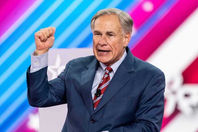 man in suit speaking on stage with raised fist