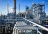 Big Oil Balks: Venezuela ‘Uninvestable’ Industrial refinery with pipelines and distillation towers under blue sky