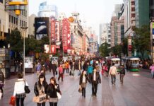 China’s Housing Reset: Drops The Hammer On Presales Crowded shopping street with pedestrians and storefronts