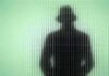 Union Boss Accused: Billionaire Tax Bombshell Silhouette of a person in a hat behind textured green glass