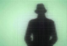 Silhouette of a person in a hat behind textured green glass