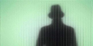 Silhouette of a person in a hat behind textured green glass