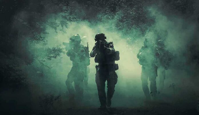 shutterstock_1045196350 Soldiers move through dense smoke in a forest
