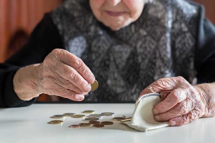 shutterstock_1086254576 Elderly person counting coins on a table
