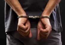 person with hands cuffed behind back