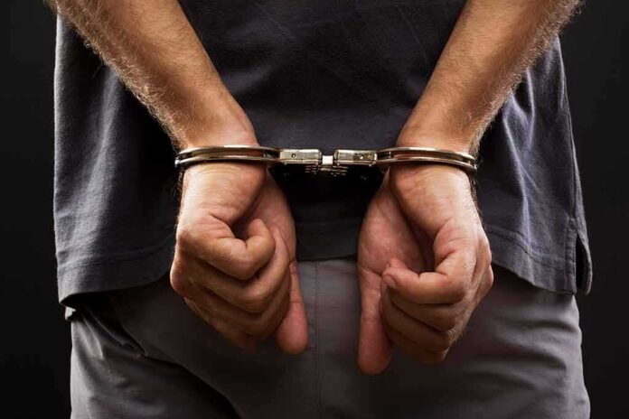 shutterstock_109783121 person with hands cuffed behind back
