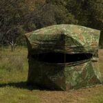 camouflage hunting blind in a grassy woodland