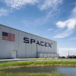 SpaceX hangar beside launch pad under blue sky
