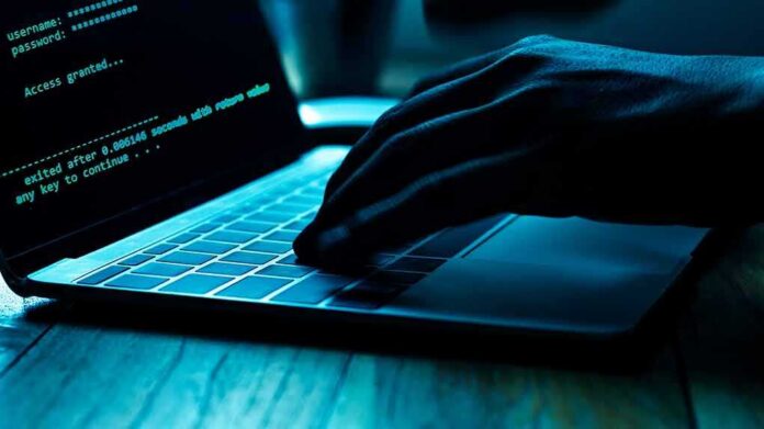 shutterstock_1166453734 Hand typing on laptop with green code on screen