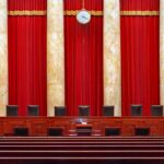 Supreme court courtroom with red curtains and empty judges' bench