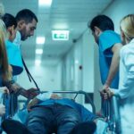 Checkpoint Carnage Hits Ambassador’s Son Medical team rushing patient on a gurney through hospital corridor