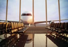 Airplane seen through terminal windows with empty gate seating