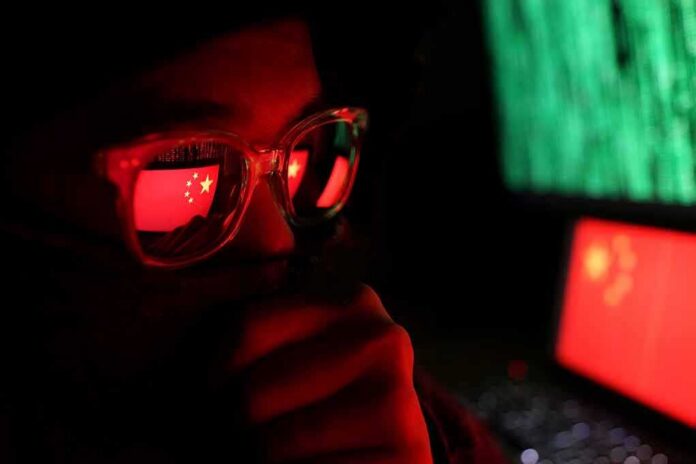 person wearing glasses with reflections of a red flag and computer screens