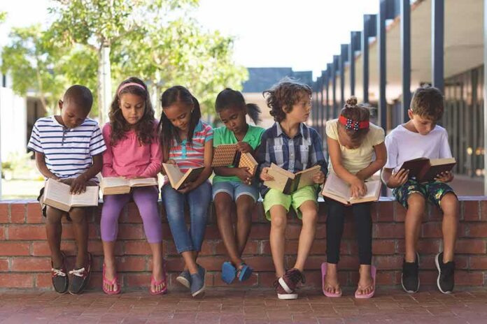 shutterstock_1352058026 children sitting on a brick ledge reading books
