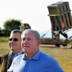 Europe Tightens Screws – Israel on Notice Ehud Barak and another man outdoors near a missile defense battery