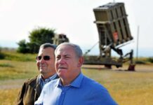 Europe Tightens Screws – Israel on Notice Ehud Barak and another man outdoors near a missile defense battery