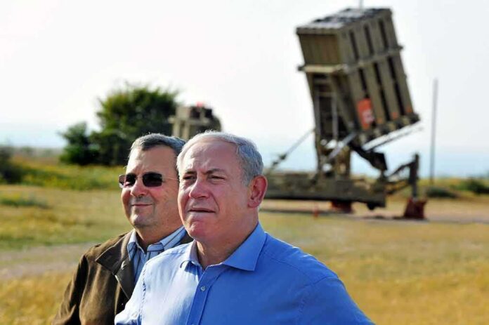 Ehud Barak and another man outdoors near a missile defense battery