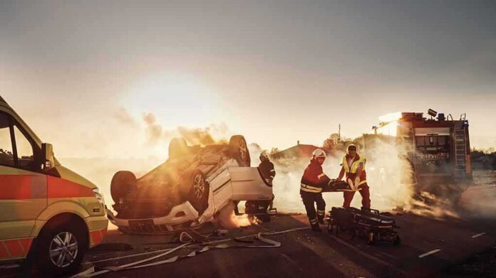 shutterstock_1721662798 Emergency responders at overturned car crash scene