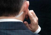 FBI: Lone Shooter – But Who Blew Security? security agent with earpiece touching ear