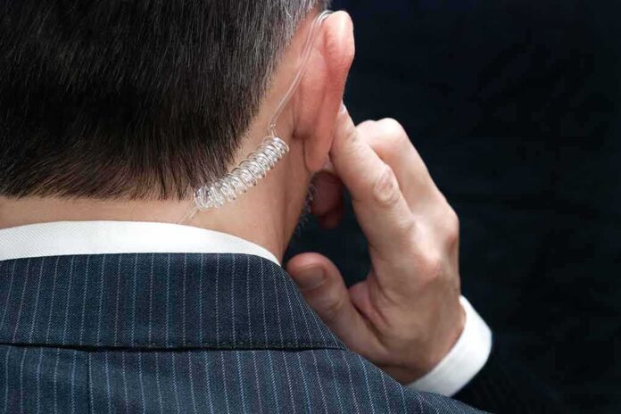 shutterstock_172646543 security agent with earpiece touching ear