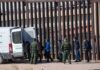 Sixteen Months, Zero Releases – Catch-And-Release Killed Border agents escort a group near a tall fence and a patrol van